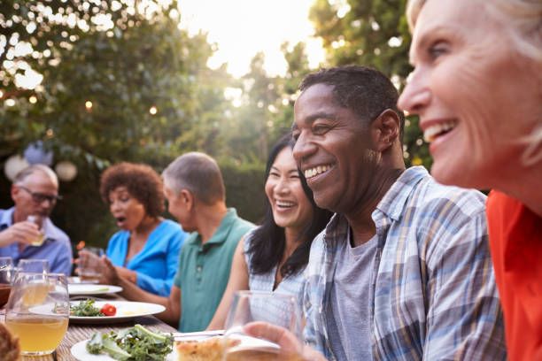 group-of-mature-friends-enjoying-outdoor-meal-in-backyard8958226459521259254